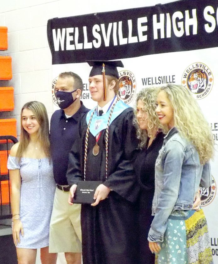 Wellsville High School valedictorian Braden Cartwright (center) poses for a quick photograph with his four guests Sunday afternoon at the district’s commencement ceremony. (Photo by Stephanie Ujhelyi)